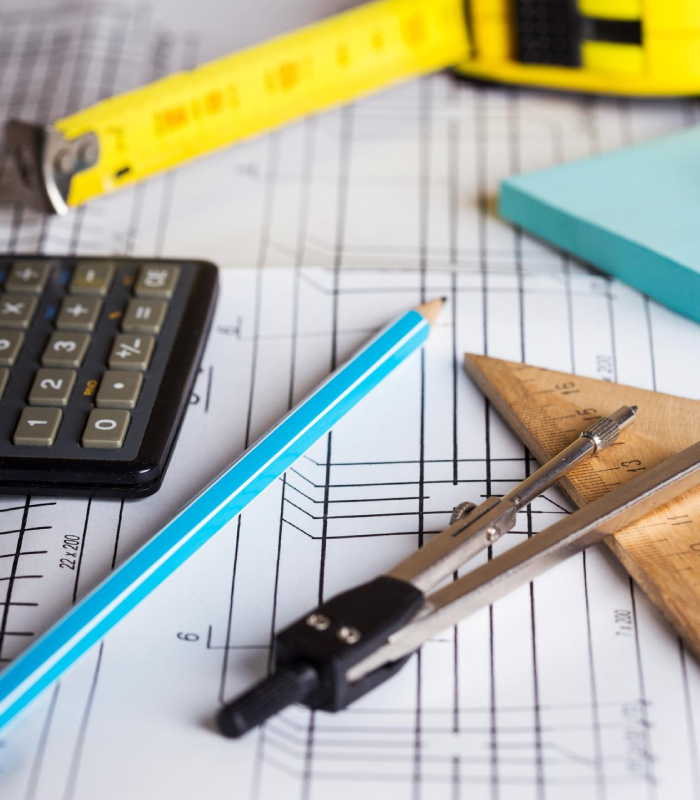 Plans de maison avec outils de mesure pour évaluer un bien immobilier