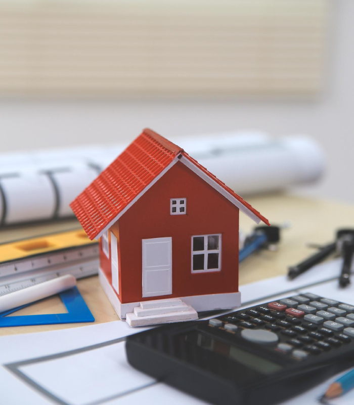 Maquette de maison avec calculatrice pour une estimation immobilière